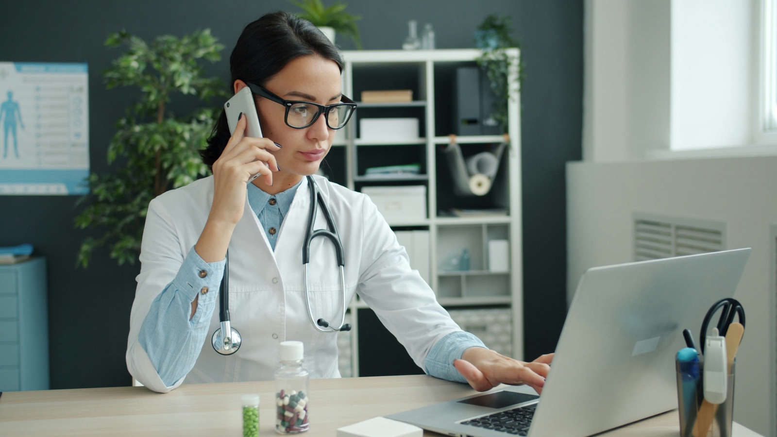 A care coordination nurse on the phone while working at a laptop