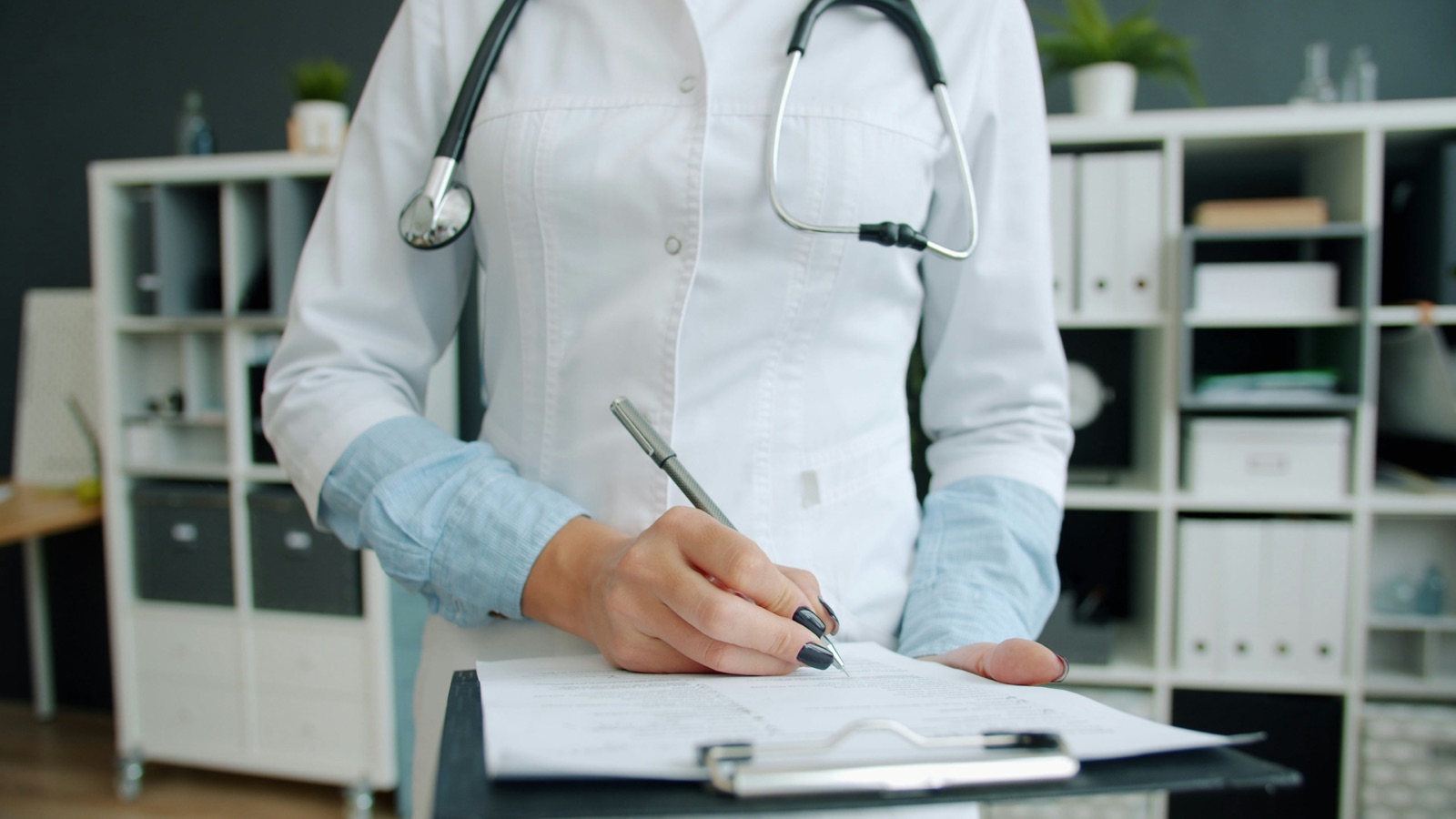 A nurse reviewing a patient chart at a desk